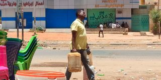 A man carries fuel containers in southern Khartoum