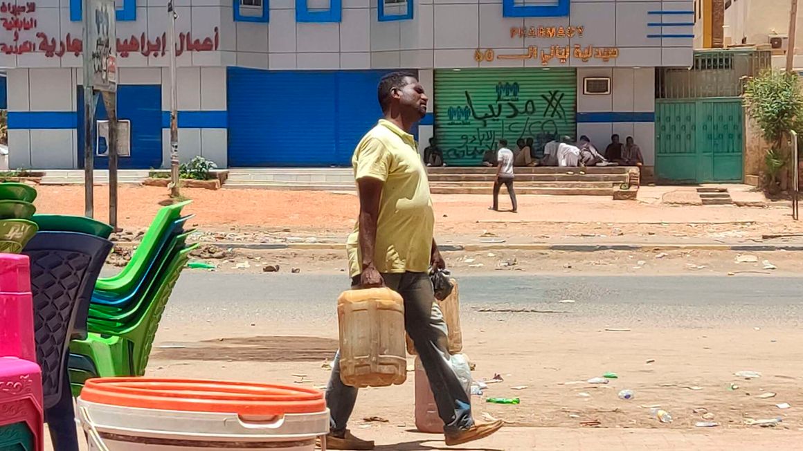 A man carries fuel containers in southern Khartoum