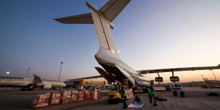 Workers load aid supplies from WHO