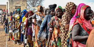Women who fled the war in Sudan queue to receive food