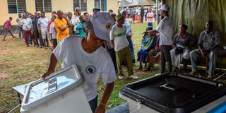 Tanzania election official prepares ballot boxes for voting 